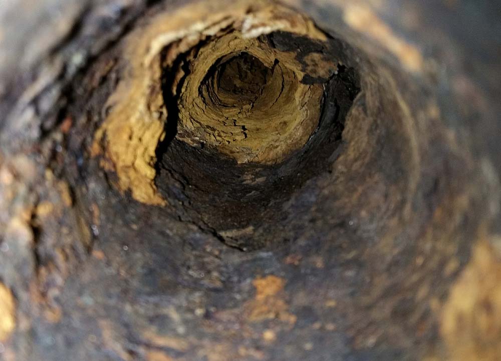 interiors of old pipe beside a newly lined pipe
