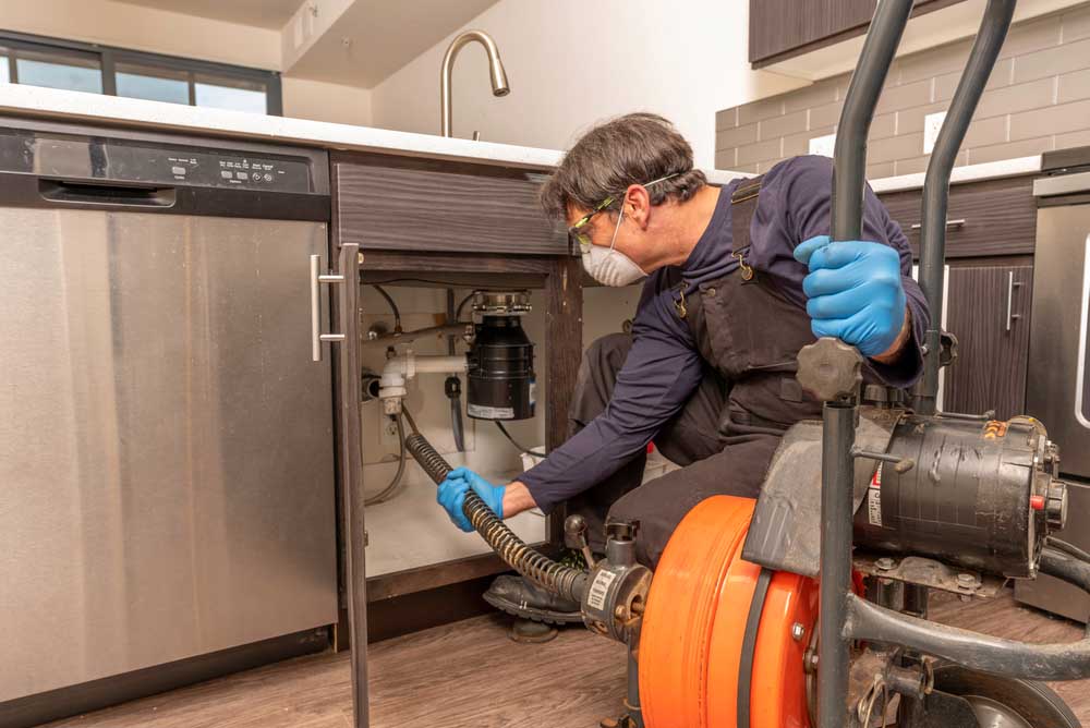 plumber operating drain cleaning equipment
